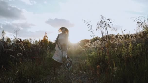 Radosna Kobieta Ukochanym Psem Biegnie Przez Zarośnięte Pole Skraju Lasu — Wideo stockowe
