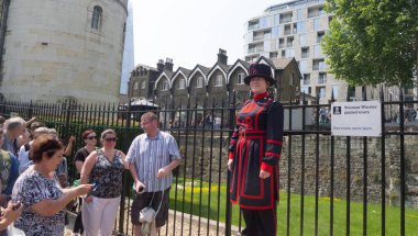 London, UK - May 26 2018: The first woman Yeomen Warder talking to visitors during a tour of the historic Tower of London