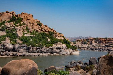 Tungabhadra nehri Hampi 'nin kayalıklarından akıyor. Vijayanagara İmparatorluğu 'nun başkenti Hampi, UNESCO' nun Dünya Mirası sitesidir..