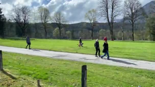 クズピッチからミュンヘンへの列車の旅の間の眺め 牧草地や雪に覆われた山以外の道を歩いている人々 — ストック動画