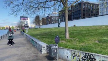 Berlin, Almanya 'da Spree nehri boyunca yürüyen insanlar