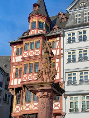 Almanya 'nın Frankfurt, Romerberg kentindeki keresteli evlerin önünde bulunan Minerva heykeli