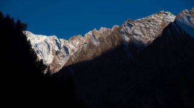 Sabah güneşi Uttarakhand, Hindistan 'daki Himalaya zirvelerini aydınlatıyor.