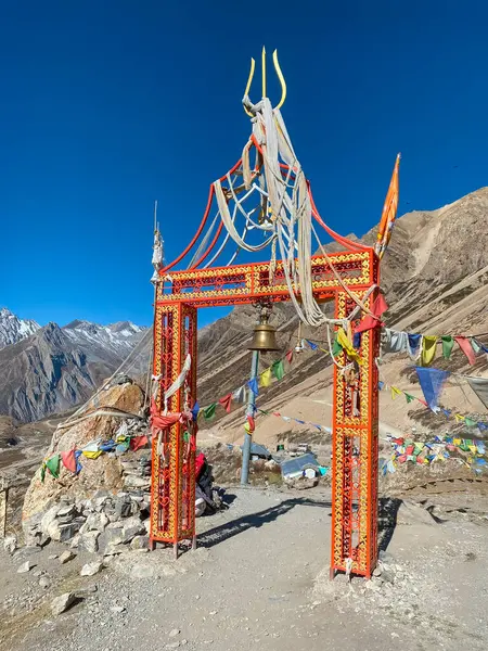 Om Parvat 'a giden yolda bayraklı ve tapınak çanlı kutsal kapı..