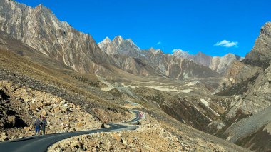 Long winding road through towering himalayan peaks on the way to Adi Kailash in Uttarakhand, India. clipart