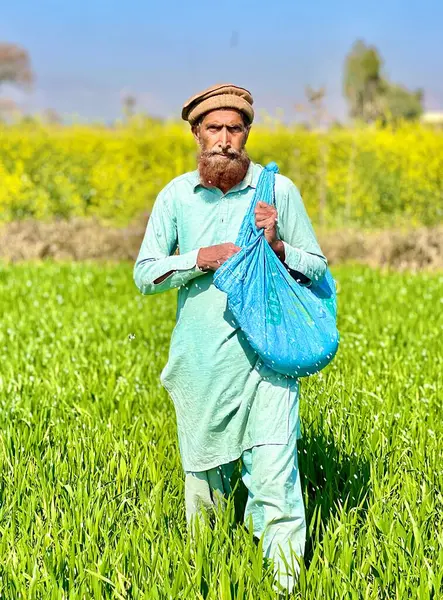 farmer with a beard and a hat of sunflower in the field