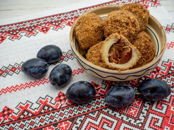 stock image sweet plum dumplings made of leavened dough and fresh plums on clay bowl and plums aside