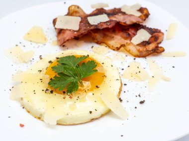 Beyaz tabakta pastırmalı kızarmış yumurta