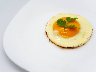 Maydanozla süslenmiş bir tabakta sahanda yumurta