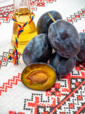 Tzoi veya toi olarak bilinen bir bardakta tuica veya tzuica olarak bilinen Romanya erik brendisi ve olgun erik yığını