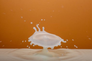 Süt havuzuna su sıçratan tek bir süt damlası soyut şekiller yaratır.