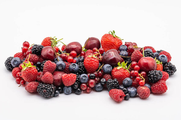 heap of assorted delicious summer fruits on white background