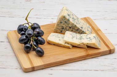 Tahta tabakta üzümle servis edilen peynir, aperatif konsepti.