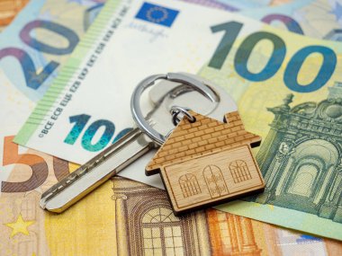 house keyring on euro banknotes. concept of house renatal, buying, insurance clipart