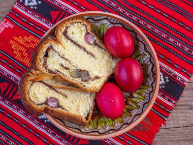 Geleneksel kumaş üzerinde ortodoks paskalya yumurtası ve sünger keki.