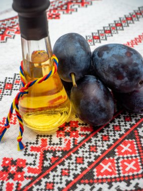 Tzoi veya toi olarak bilinen bir bardakta tuica veya tzuica olarak bilinen Romanya erik brendisi ve olgun erik yığını