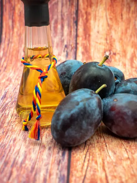 Tzoi veya toi olarak bilinen bir bardakta tuica veya tzuica olarak bilinen Romanya erik brendisi ve olgun erik yığını