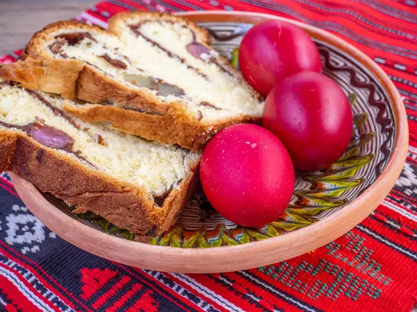 Geleneksel kumaş üzerinde ortodoks paskalya yumurtası ve sünger keki.