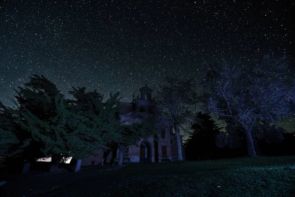 夜间长期曝光摄影 背景为星星 前景为教堂和树木 — 图库照片