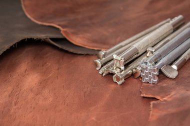 Doğal dana derisi parçaları ve deri işleme aletleri. Deri ustası atölyesi..