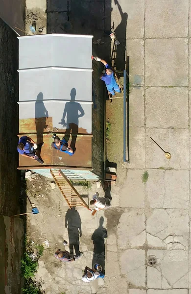 Elongated Shadow Silhouettes Workers While Painting Old Rusty Transformer Cabinet Obrazek Stockowy