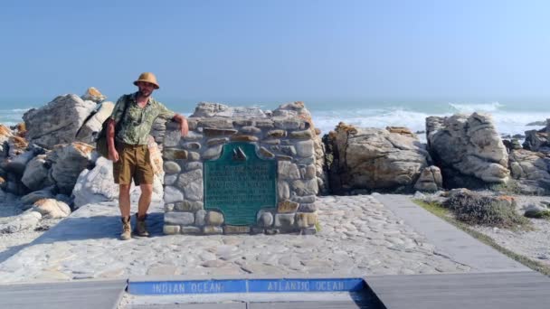 暑假在海滨放松一下 在南非好望角的石头上摆姿势的漫游者 海滨公园里头戴草帽的人欣赏着迷人的自然景观 — 图库视频影像