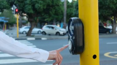 Yaya geçidi yaya geçidinde yürüyor. Sadece vücut. Tanınmayan insanlar. Yaya geçidinden geçen bir kadın. Bir kadının eli, yaya geçidindeki bir düğmeye basar.