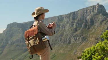 Doğa fotoğrafçısı iş başında. Bulutların üzerindeki kadın silueti, sabah tepesi manzarası. Fotoğrafçı, dağlarda dijital kamerayla fotoğraf çekiyor. Yaratıcı profesyonel fotoğrafçılık