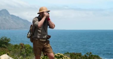 Doğa fotoğrafçısı iş başında. Sisli bulutların üzerindeki insan silueti, sabah tepesi manzarası. Fotoğrafçı, dağlarda dijital kamerayla fotoğraf çekiyor. Yaratıcı profesyonel fotoğrafçılık