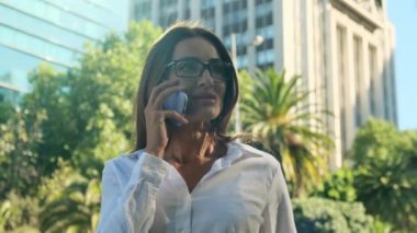 Gözlüklü, gülümseyen İspanyol iş kadını açık havada konuşuyor. Akıllı telefon ses tanıma sistemi kullanan komik Brezilyalı genç bir kadın. Düşünceli genç bayan telefonda konuşuyor.