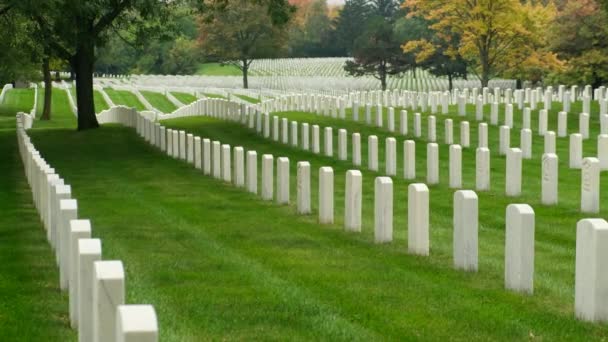 アメリカの戦死者を称えるためにアーリントン国立墓地の墓石に旗が置かれている 無名の兵士の墓は カメラの天までパンします 知られざるアメリカ兵のマッキンアック砦戦争墓 — ストック動画