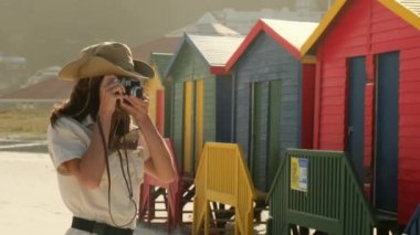 Sırt çantalı kız turist renkli evlerin yanındaki sahilde duruyor. Sinema ve ilham verici seyahat blogcusu canlı motivasyon macerası. Yeni nesil yeni konsept seyahatler. Heyecanlı dünya kaşifi