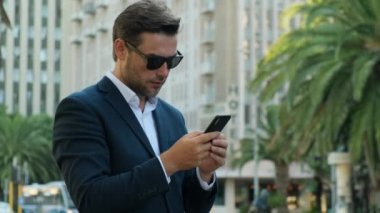 businessman extremely happy after read message in mobile phone Excited employee looking at screen and pleased rejoices received great news on smartphone. entrepreneur celebrating business success