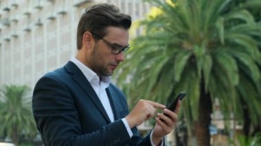 businessman extremely happy after read message in mobile phone Excited employee looking at screen and pleased rejoices received great news on smartphone. entrepreneur celebrating business success
