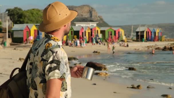 Male Traveler Sun Hat Drinks Hot Tea Ocean Background Colored — Stockvideo