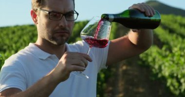 Authentic shot of happy handsome elegantly dressed man is tasting a flavor and drinking fresh wine. successful man in white polo drinking white wine from glass at winery. sommelier man sniffing wine