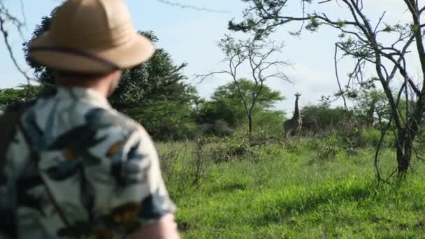 サファリスタイルの旅行者はサバンナで動物を撮影します 観光ケニアアフリカサファリアドベンチャー休暇で 野生のサーチライオンズとキリンマサイマラ サファリハットの男性が — ストック動画