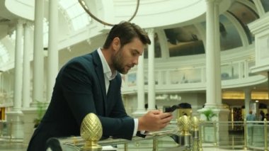 Erkek milenyum profesyoneli modern akıllı telefon mesajı tutuyor. Genç işadamı iş zamanı yönetim konsepti için yararlı mobil uygulamalar kullanıyor.