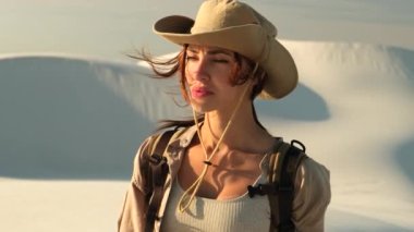 Çölde dar bir kanyonda yürüyen bir kadın. Güneş şapkalı kadın gezgin çölde kum tepelerinin arkasında duruyor. Bir turist Afrika çölünde kayboldu, etrafta kimse yok.