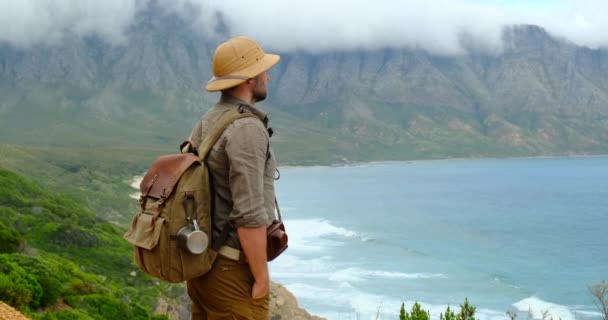 マウンテンピークの上に立つハイキングサンセットアドベンチャースピリット成功自然美の達成自由探査を見てください 自然景観の中に立つ現代旅行男のビデオカメラマン — ストック動画