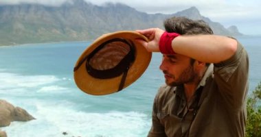 a male traveler in safari clothes climbs high on the peak of the mountain with sport hiking shoes. A traveler man is engaged in hiking breathes mountain air enjoys loneliness