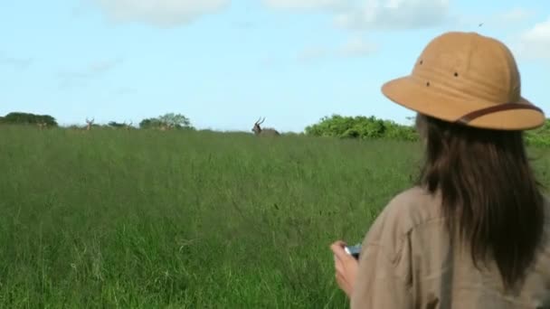 非洲妇女在沙漠度假是为了旅行 自由和冒险 在肯尼亚的大自然里 一个夏天 女人在一个游乐园里散步 一个戴着狩猎帽的女孩在狩猎公园拍照 — 图库视频影像