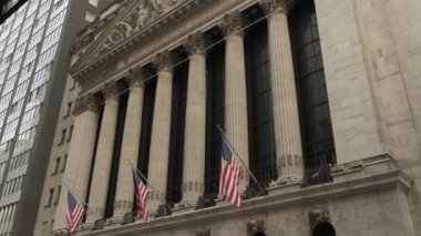 Ünlü Wall Street ve New York 'taki bina, vatansever bayrağıyla New York Borsası. New York Borsası 'nın köşesindeki Wall Street yol tabelası. New York Borsası