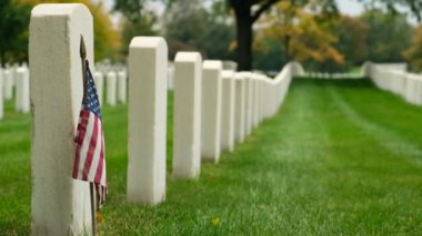 Sunset 'te Amerikan bayrakları. Mezarlıktaki anma günü anısına mezar taşlarında bayraklar var. Ulusal Mezarlıkta küçük Amerikan bayrakları ve mezar taşları Anma Günü sergisi.