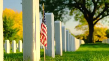 Sunset 'te Amerikan bayrakları. Mezarlıktaki anma günü anısına mezar taşlarında bayraklar var. Ulusal Mezarlıkta küçük Amerikan bayrakları ve mezar taşları Anma Günü sergisi.