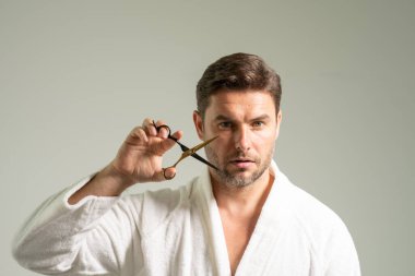 Aynanın karşısında elinde makas ve tarak tutan seksi adam aynaya bakıyor, güzellik hizmetlerinin keyfini çıkarıyor saç bakım ürünlerinden, saç kesiminden, berber işinden, saç kesiminden tatmin oluyor.