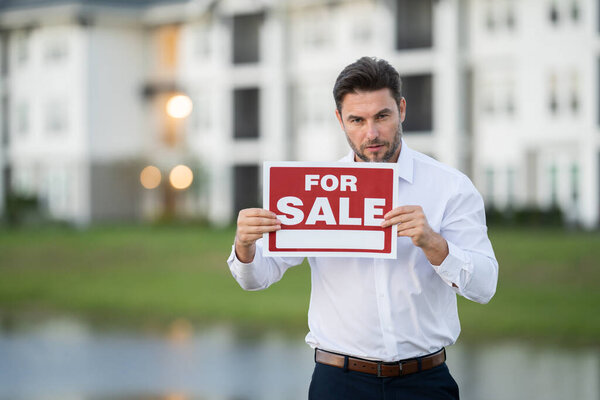 Бизнесмен покупает и продает дома и недвижимость. Настоящий агент штата дает новый ключ от дома. Агент по недвижимости с клиентом до подписания контракта. мужчина реальный агент государства с табличкой на продажу или аренду.