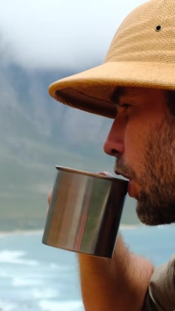Ένας Άντρας Πεζοπόρος Ταξιδιωτικό Κύπελλο Κάθεται Μια Βουνοκορφή Πίνοντας Ζεστό — Αρχείο Βίντεο