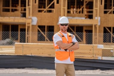 İnşaat alanındaki çatı ustası, Rıhtım inşaatında çalışıyor. Kameraya gülümseyen kasklı yakışıklı, genç bir müteahhit. Görevli inşaat işçisi. Müteahhit ve Tahta Ev Çerçevesi