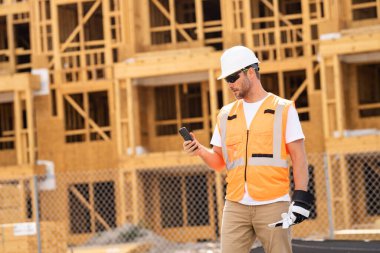 İnşaat alanındaki çatı ustası, Rıhtım inşaatında çalışıyor. Kameraya gülümseyen kasklı yakışıklı, genç bir müteahhit. Görevli inşaat işçisi. Müteahhit ve Tahta Ev Çerçevesi